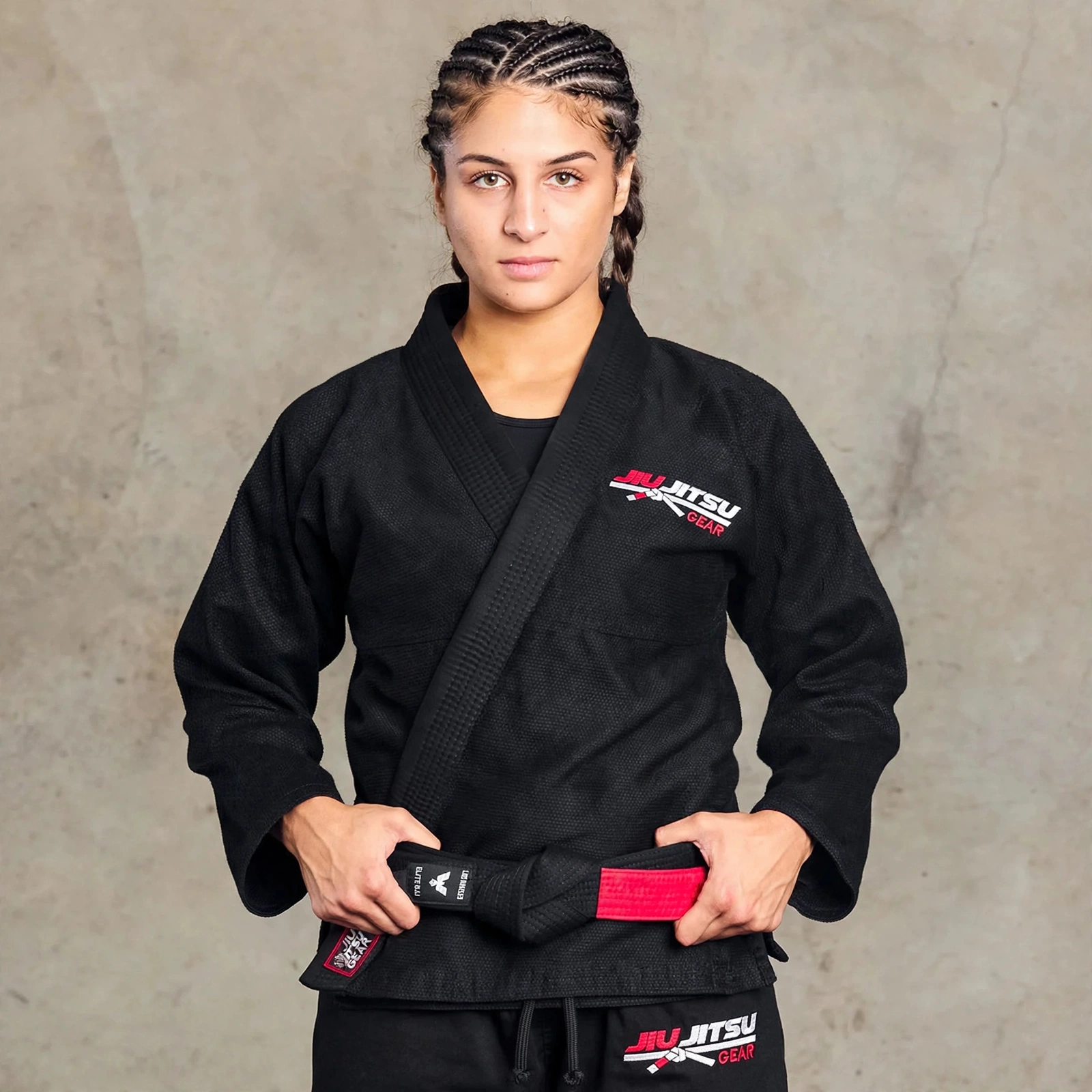 Female BJJ athlete wearing black JIU JITSU GEAR Brazilian Jiu Jitsu Gi set - pearl weave jacket with red white embroidered logo on chest and matching ripstop pants with logo on thigh - size A1